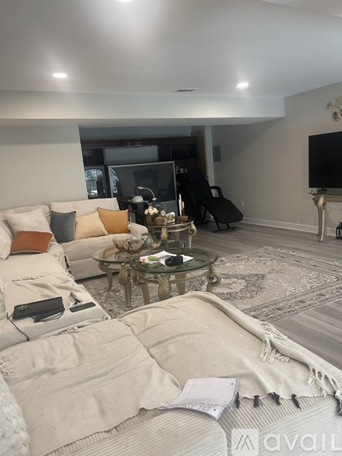 A living room with a glass coffee table and a white couch.