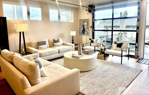 A living room with a white couch and a large window.