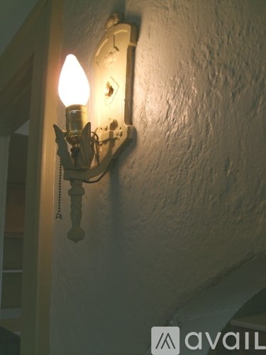 A wall mounted light fixture with a white background.