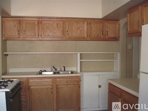 A kitchen with wooden cabinets and a white stove.