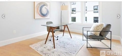 A modern living room with a black chair and a white rug.