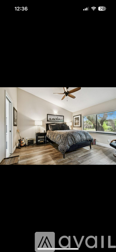 A bedroom with a bed, dresser, and ceiling fan.