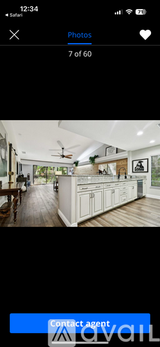A kitchen with white cabinets and a wooden floor.