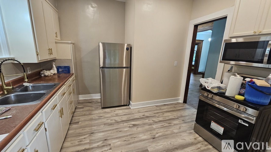 A kitchen with a refrigerator, sink, and stove top oven.