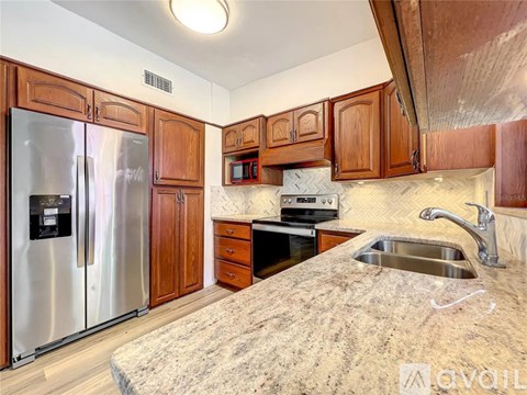 A kitchen with wooden cabinets and a granite countertop.