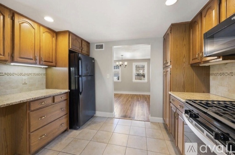 A kitchen with wooden cabinets and black appliances.
