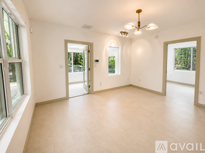A spacious room with a ceiling fan and large windows.