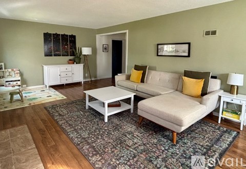A living room with a white couch and a white coffee table.