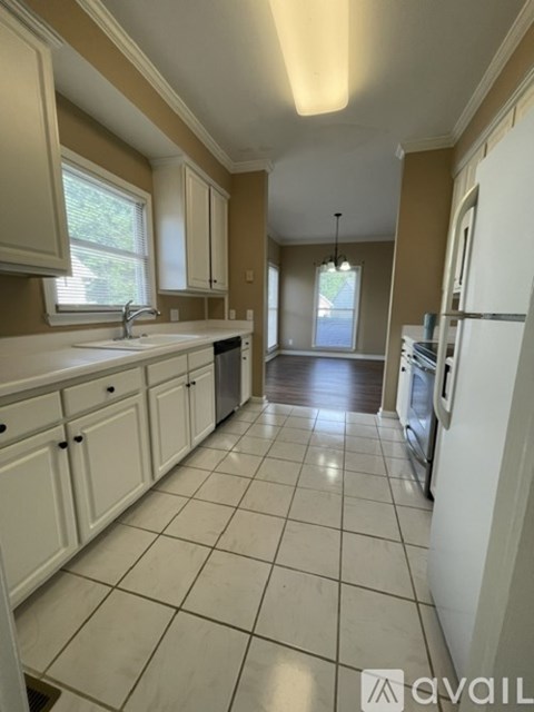 A kitchen with white cabinets and a white fridge.