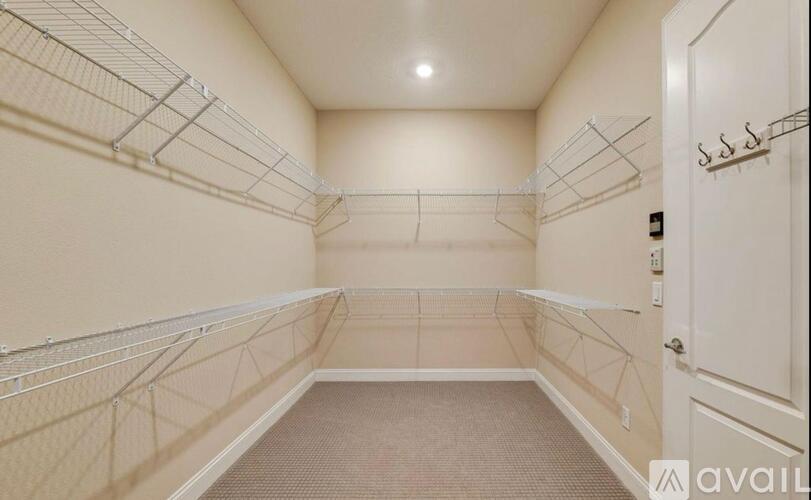 A sparsely furnished room with a carpeted floor and a door on the right.