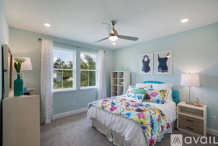 A bedroom with a large bed and a ceiling fan.