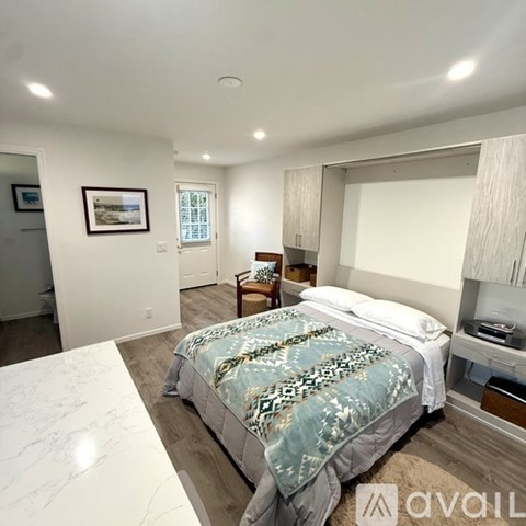 A bedroom with a large bed and a framed picture on the wall.