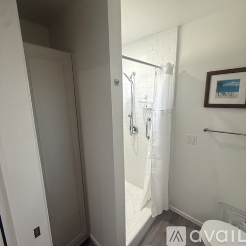 A white bathroom with a shower and a toilet.