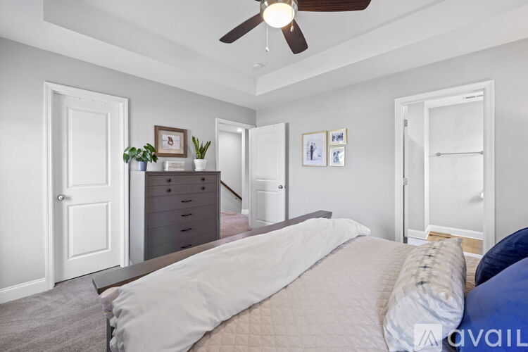 A bedroom with a large bed and a ceiling fan.