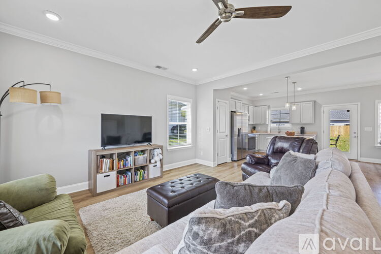 A living room with a grey couch and a black ottoman.
