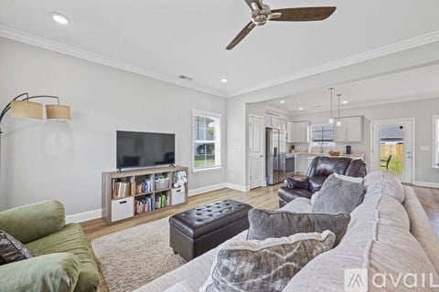 A living room with a grey couch and a black ottoman.