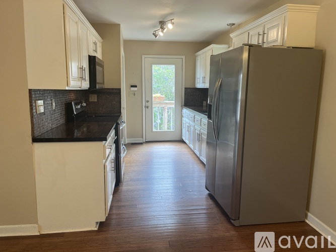 A kitchen with a refrigerator on the right side.