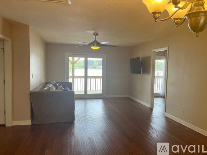 A living room with a grey couch and a ceiling fan.