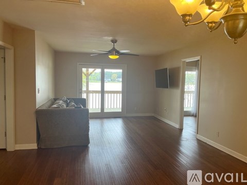 A living room with a grey couch and a ceiling fan.
