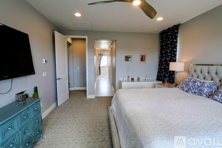 A bedroom with a large bed and a television on the wall.