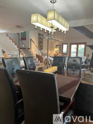 A modern dining room with a long table and chairs.