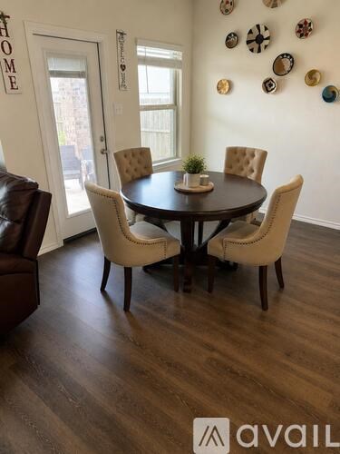 A dining room with a table and chairs.