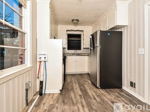 A kitchen with a black fridge and a white fridge.