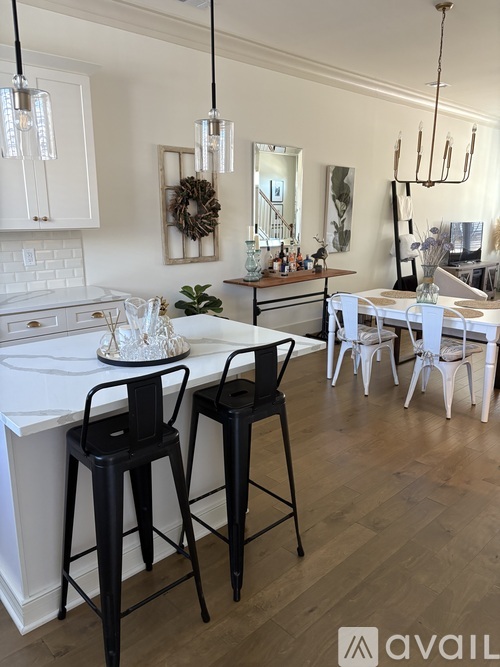 A kitchen with white cabinets and a wooden floor.
