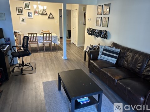 A living room with a brown leather couch and a coffee table.