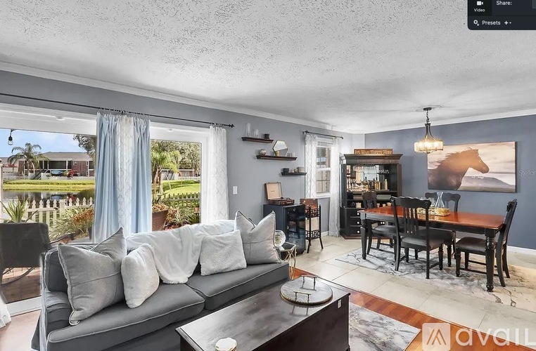 A living room with a grey couch and a dining table.