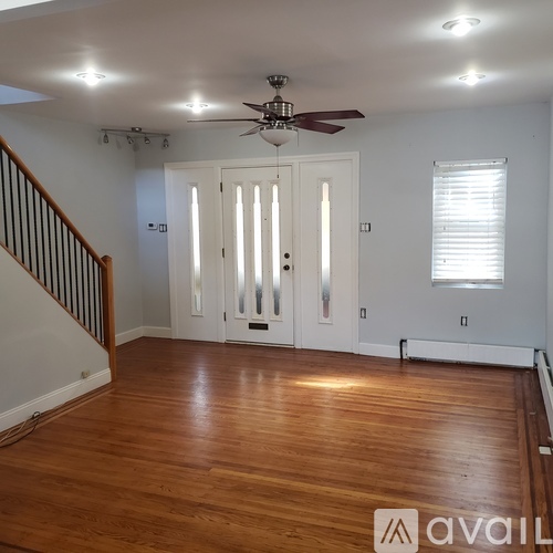 A room with wooden floors and a ceiling fan.