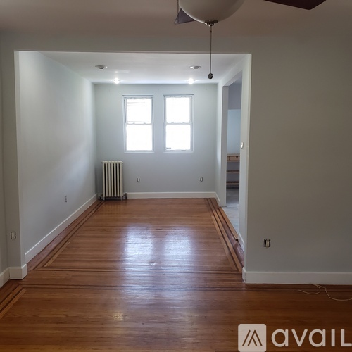 A room with wooden floors and a ceiling fan.