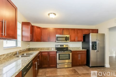 A kitchen with brown cabinets and stainless steel appliances.