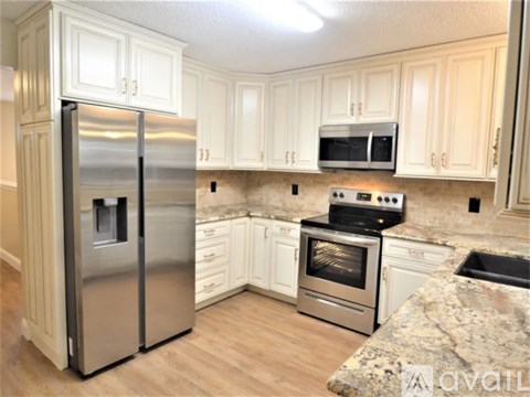 A kitchen with a stainless steel refrigerator, oven, and microwave.