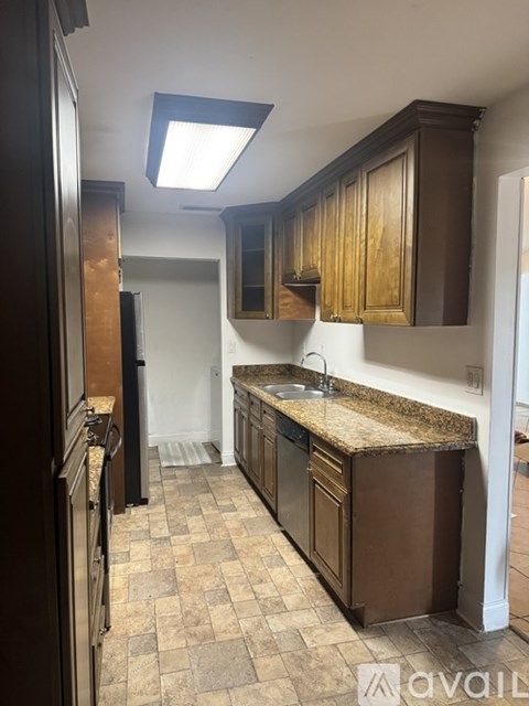 A kitchen with brown cabinets and a granite countertop.