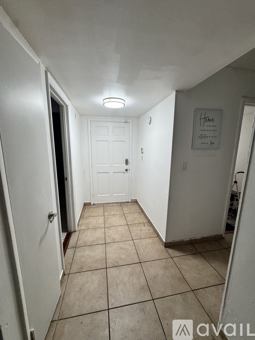A hallway with tiled floors and white walls.