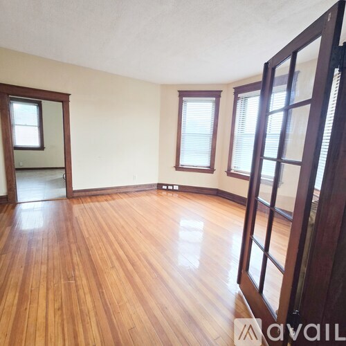 A room with wooden floors and a large mirror on the wall.