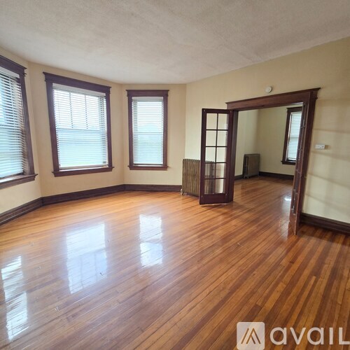 A room with wooden flooring and a large mirror on the wall.