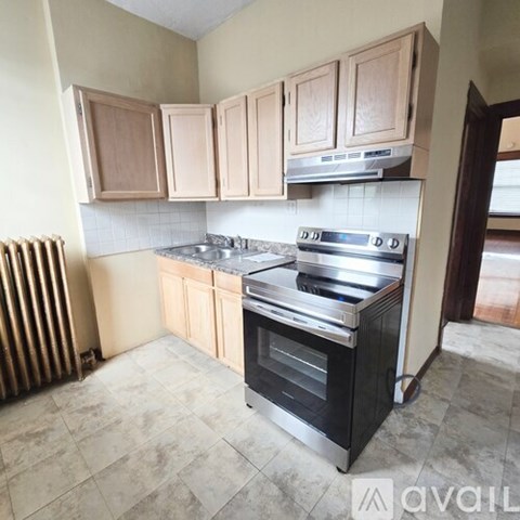 A kitchen with wooden cabinets and a stainless steel stove.