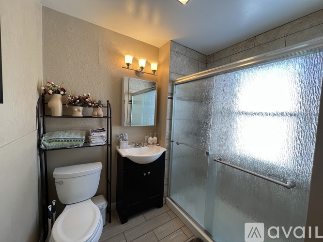 A bathroom with a toilet, sink, and a mirror.