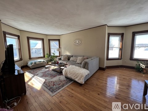 A living room with a grey couch and a wooden floor.