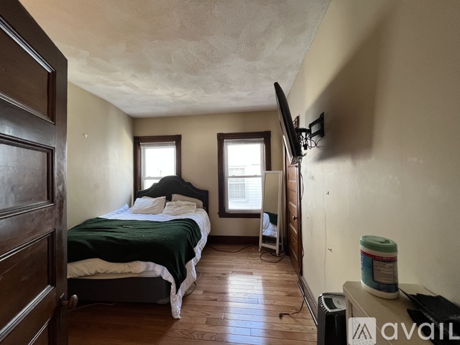 A bedroom with a bed, a chair, and a window.