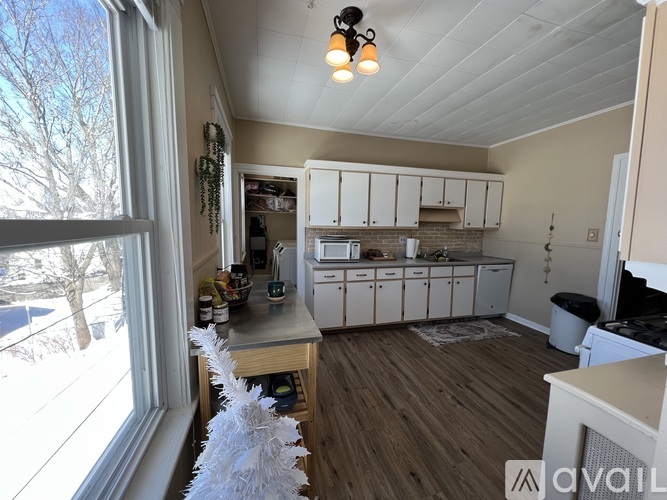 A kitchen with white cabinets and a wooden floor.