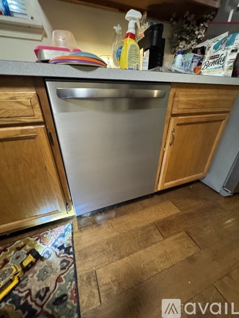A kitchen with a dishwasher and wooden cabinets.