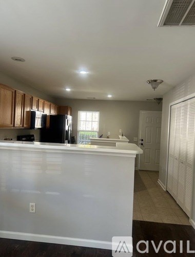 A kitchen with white countertops and wooden cabinets.
