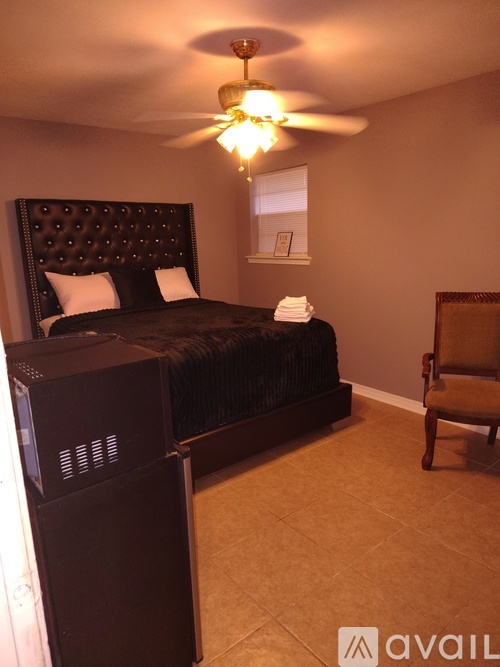 A bedroom with a large bed and a ceiling fan.