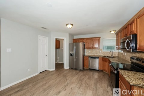 A kitchen with wooden cabinets and a stainless steel refrigerator.