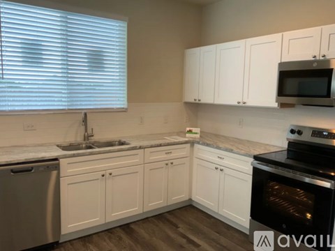 A kitchen with white cabinets and a black oven.