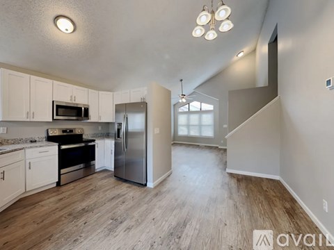 A kitchen with white cabinets and a stainless steel refrigerator.
