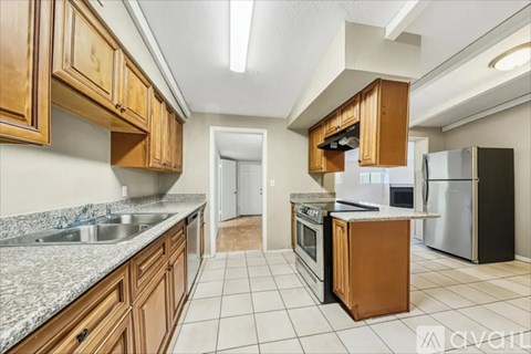 A kitchen with wooden cabinets and a granite countertop.